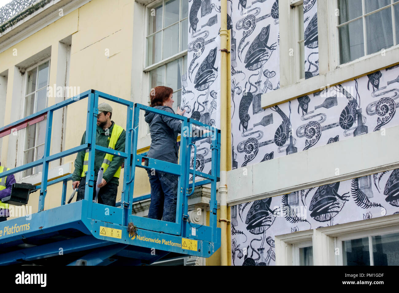 Künstler Astrid Jaekel tapezieren die ausserhalb eines von mehreren Gebäuden in Wigtown für der Stadt jährliche Book Festival 21-30 September 2018. Stockfoto