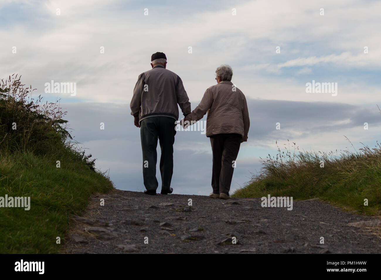 Ein älteres Ehepaar gemeinsam erklimmen einen Hügel Stockfoto