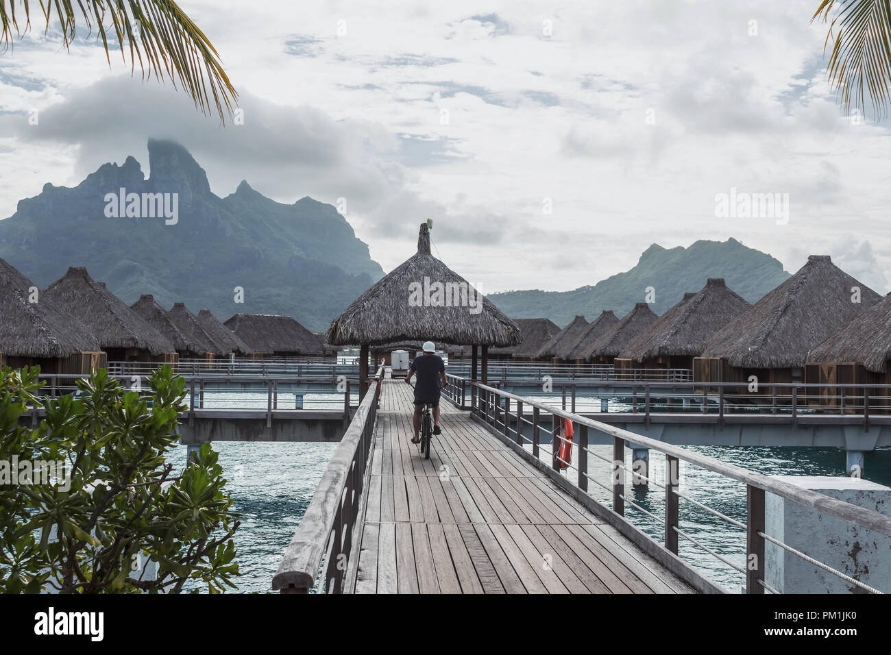 Mann reiten Fahrrad auf der Insel Bora Bora mit Berg Otemanu hinter, Französisch Polynesien Stockfoto