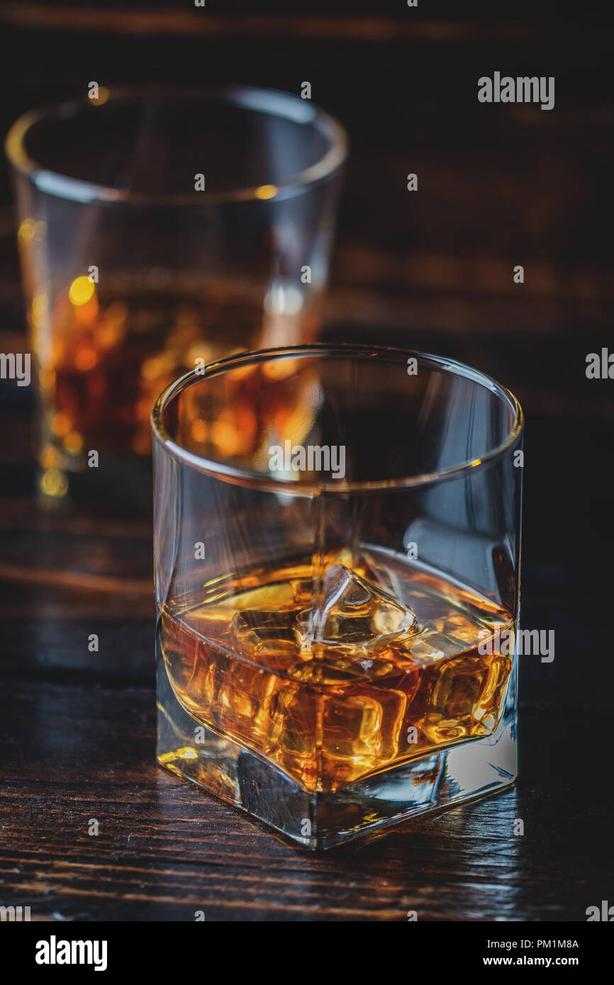 Alkohol trinken Whisky, Whiskey oder Bourbon mit Eiswürfeln auf dunklem Holz Tisch Stockfoto