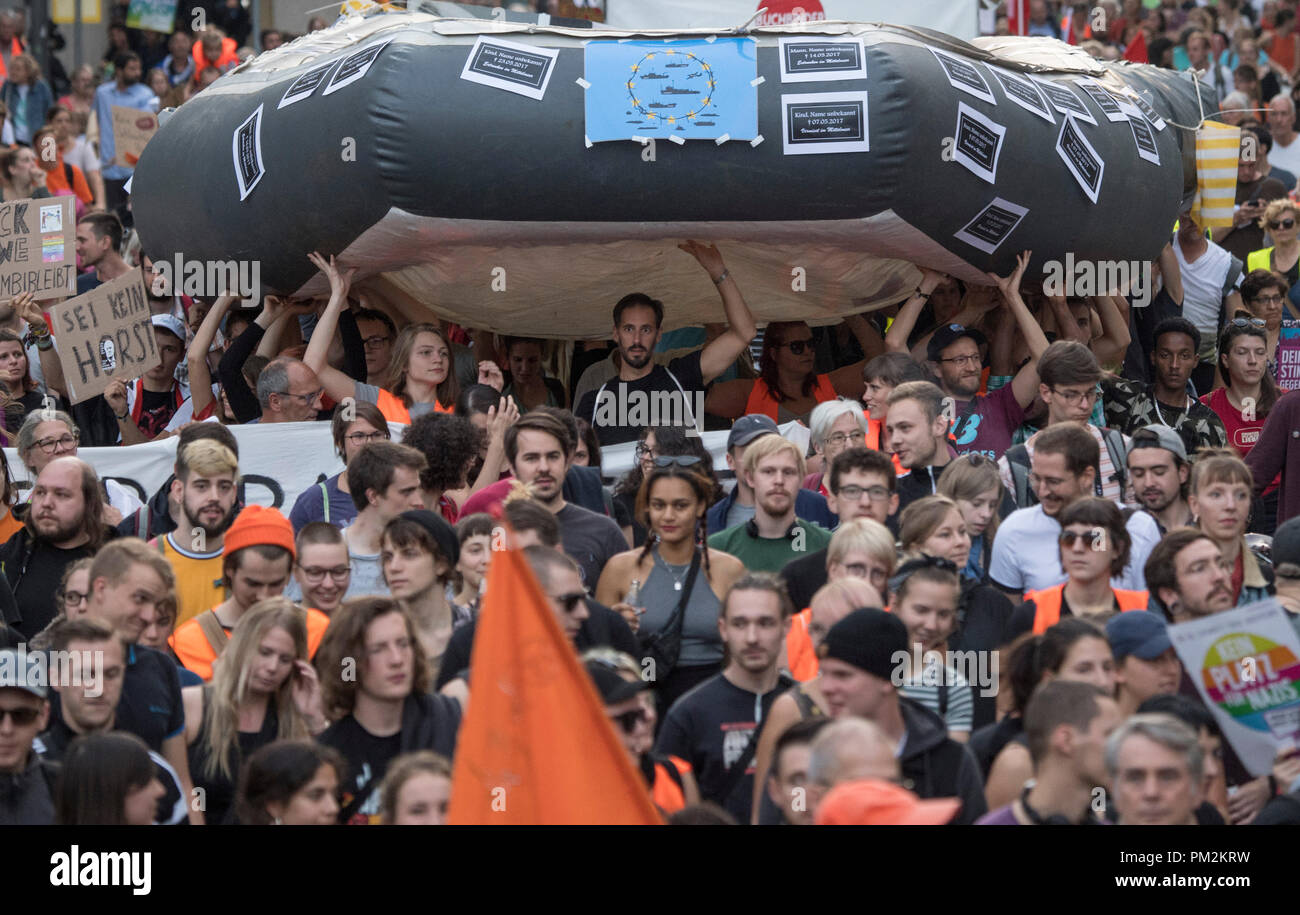 17. September 2018, Hessen, Frankfurt_Main: Mehrere tausend Menschen, die sich in einem gemeinsamen Demonstrationszug durch die Innenstadt. Sie tragen ein riesiges Schlauchboot, die auch von Flüchtlingen auf dem Mittelmeer verwendet wird. Auf Banner und Plakate, die Sie für eine Änderung in der Migrationspolitik in Deutschland anzurufen und gegen Bundesminister Horst Seehofer (CSU). Foto: Boris Roessler/dpa Stockfoto
