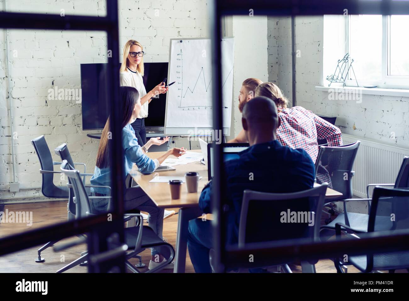 Arbeiten hart, um zu gewinnen. Geschäftsfrau, die Durchführung einer Präsentation mit Flipchart, während in der kreativen Arbeiten im Büro. Stockfoto