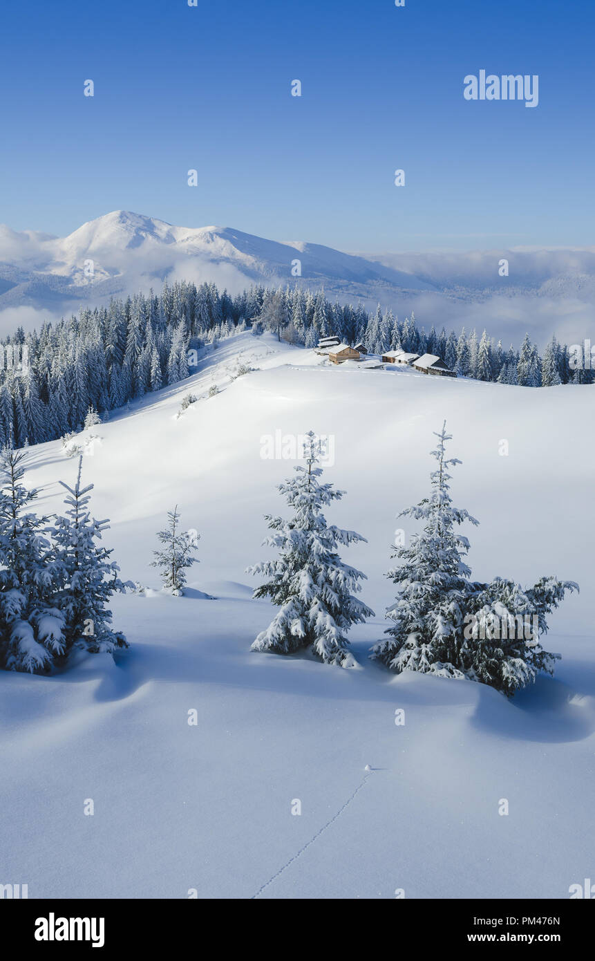 Schönen winter Bergkulisse. Anzeigen von Holzhütten und Top. Sonniges Wetter einem frostigen Tag. Strahlend blauer Himmel Stockfoto