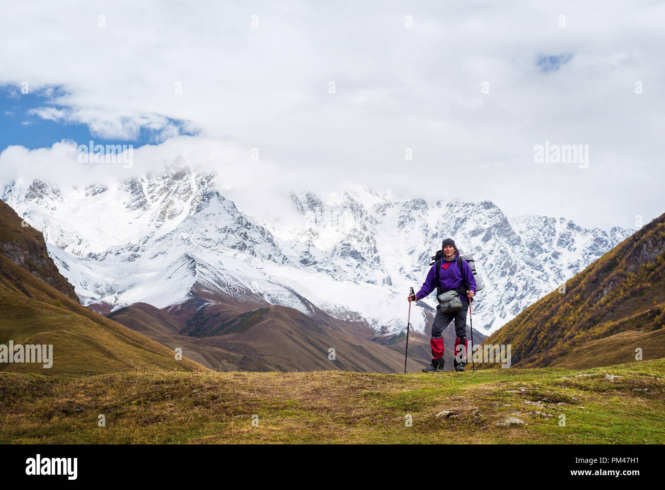 Touristen mit einem Rucksack in eine Wanderung. Trekking in der Nähe der Berg Shkhara. Main kaukasischen Ridge. Zemo Swanetien, Georgia. Herbst Landschaft mit einem Höchststand im Th Stockfoto