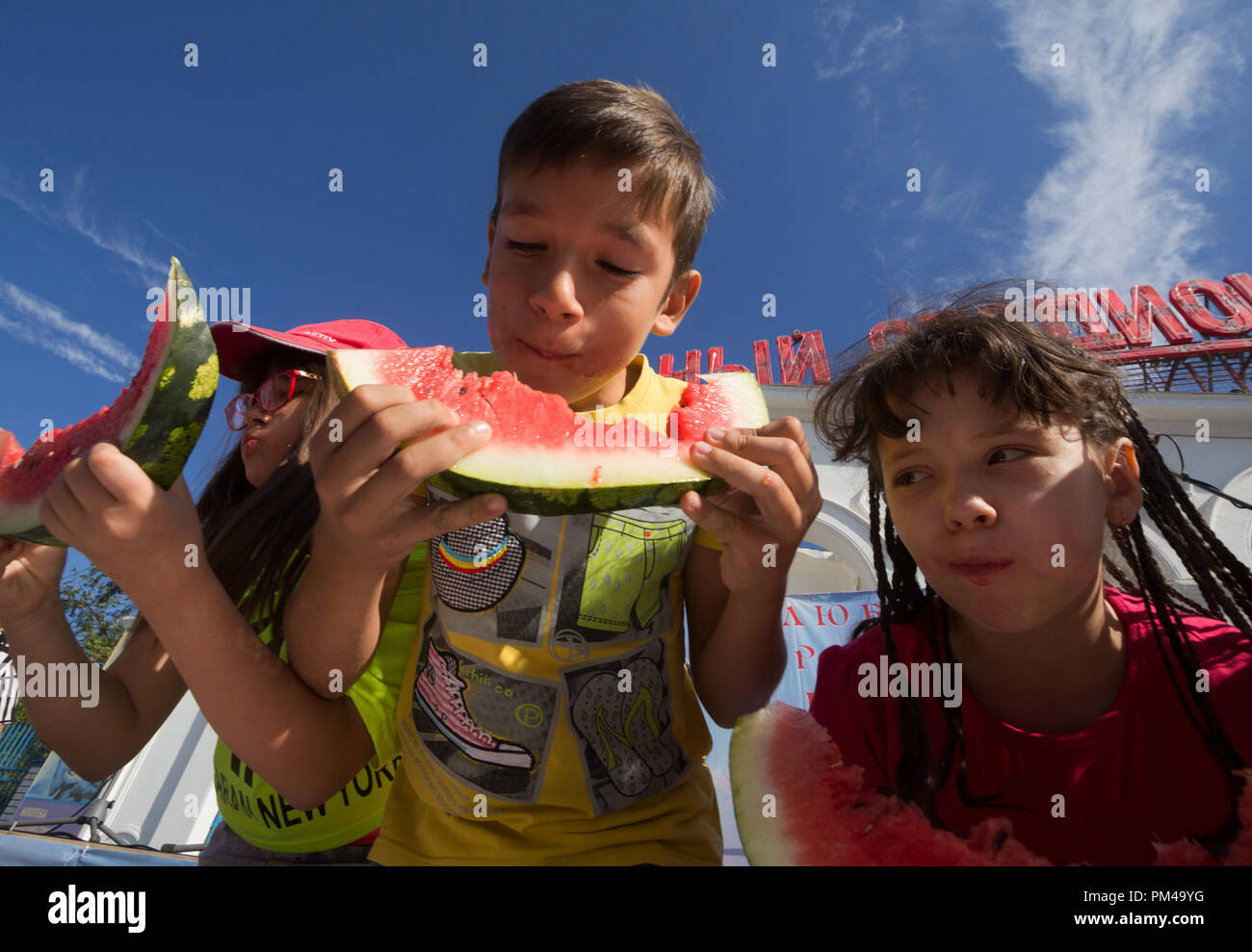 Kinder essen Wassermelonen an der Jahreszeit fairen Markt in Astrachan, Russland Stockfoto
