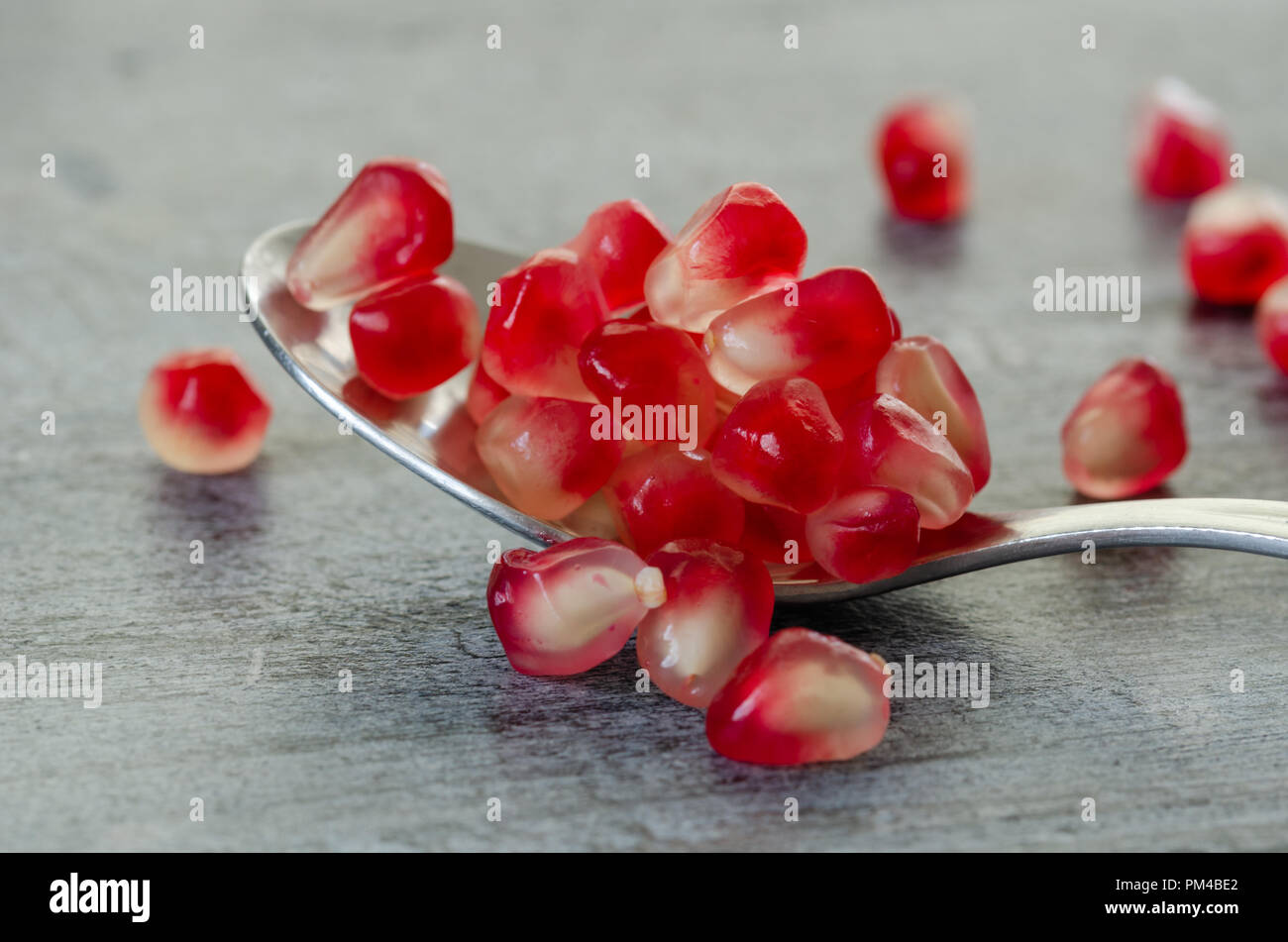 Granatapfel Samen werden in Löffel auf Holztisch. Nahaufnahme, Detail. Stockfoto