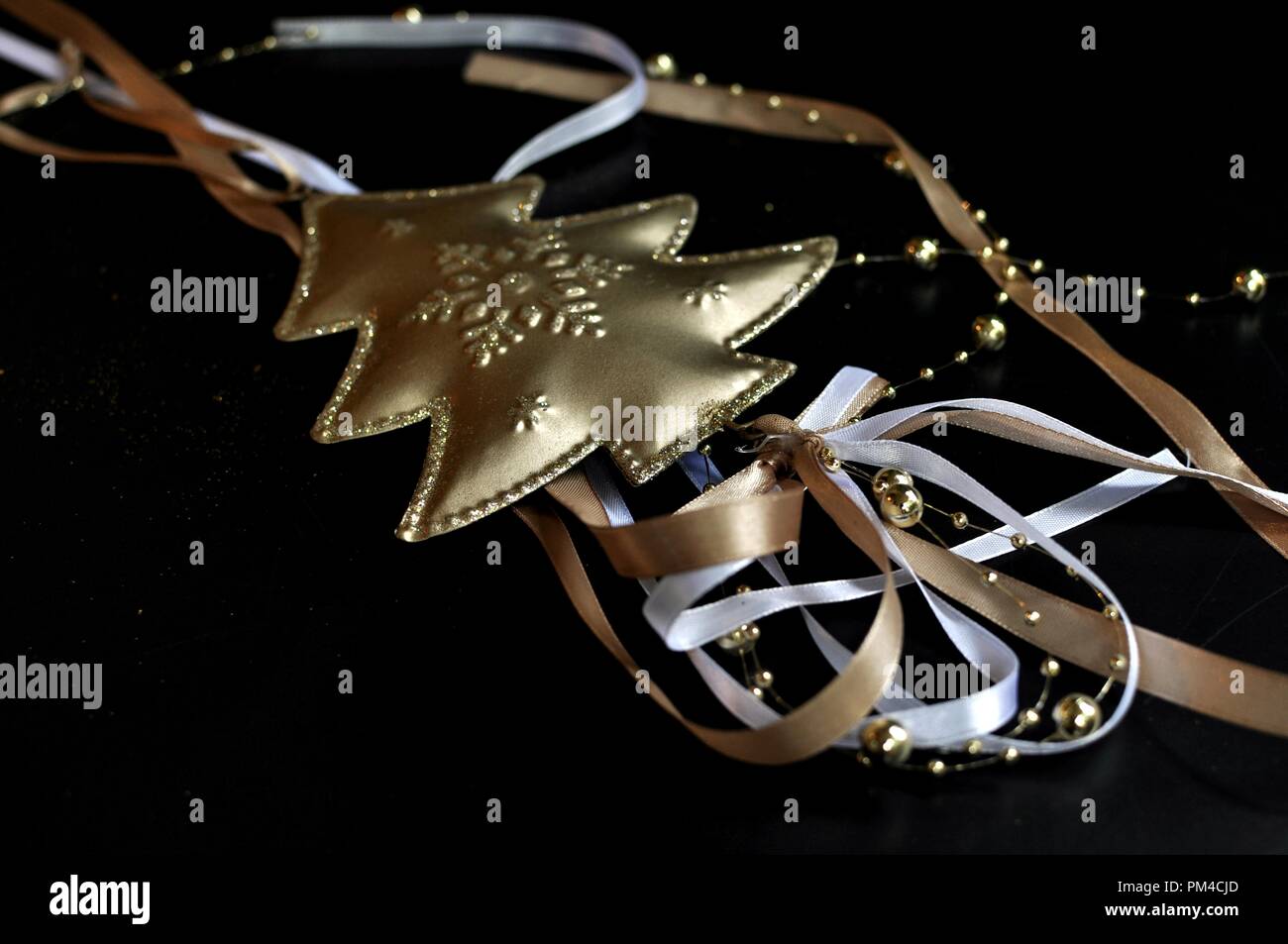 Weihnachten Dekoration mit einem Golden Tree mit farbiger Schnürung auf schwarzem Hintergrund. Kopieren Sie Raum, Vorderansicht Stockfoto