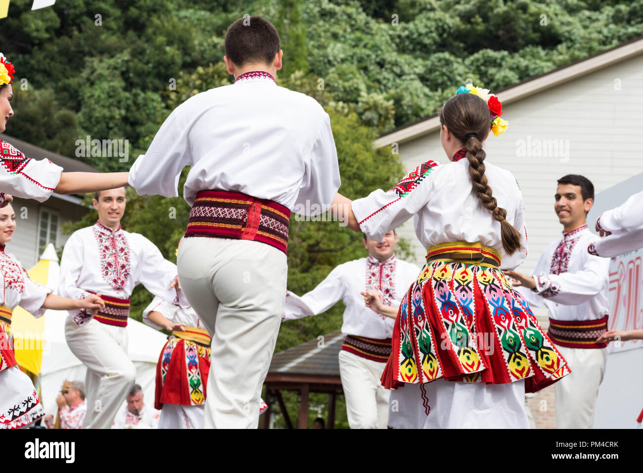 Bulgarischen Tänzer in traditioneller Kleidung bilden einen Kreis beim Tanzen bulgarische Volkstanz während Bulgarien Festival in Munakata, Fukuoka, Japan 2018 Stockfoto