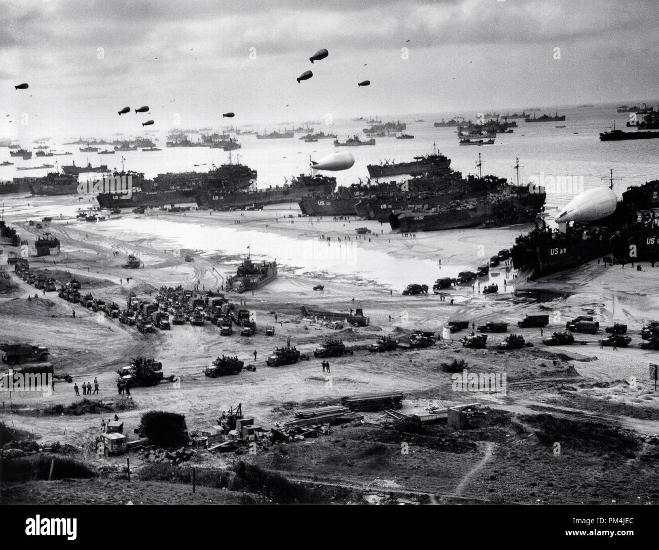Landenden Schiffe Fracht an Land setzen auf Omaha Beach, bei Ebbe in den ersten Tagen nach der Operation, Mitte Juni, 1944. Unter identifizierbaren Schiffe vorhanden sind LST-532 (in der Mitte der Ansicht); USS LST LST-262 (3. von rechts); USS LST LST-310 (2. von rechts); USS LST-533 (teilweise sichtbar Ganz rechts) und USS LST-524. Hinweis Barrage balloons Overhead und Armee "Half-track-Konvoi bilden bis auf den Strand. Die LST-262 war einer von 10 Coast Guard - Bemannte LSTs, die in der Invasion in der Normandie, Frankreich, Juni 1944 Datei Referenz Nr. 1003 689 THA teilgenommen Stockfoto