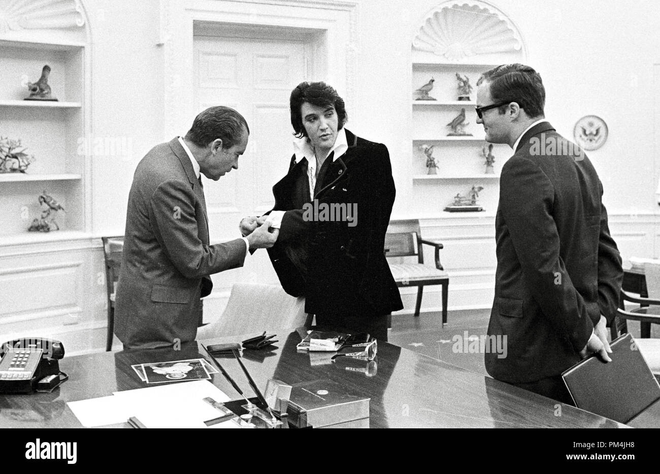 Elvis Presley zeigt Präsident Richard Nixon seine Manschettenknöpfe Dezember 21, 1970 im Weißen Haus. Foto von Ollie Atkins/NARA Datei Referenz Nr. 1003 773 THA Stockfoto