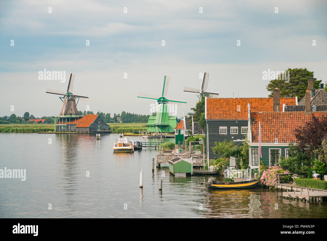 De Gekroonde Poelenburg, De Kat, Windmühle De Zoeker Windmühle und Blick auf den Fluss in Zaandijk, Niederlande Stockfoto