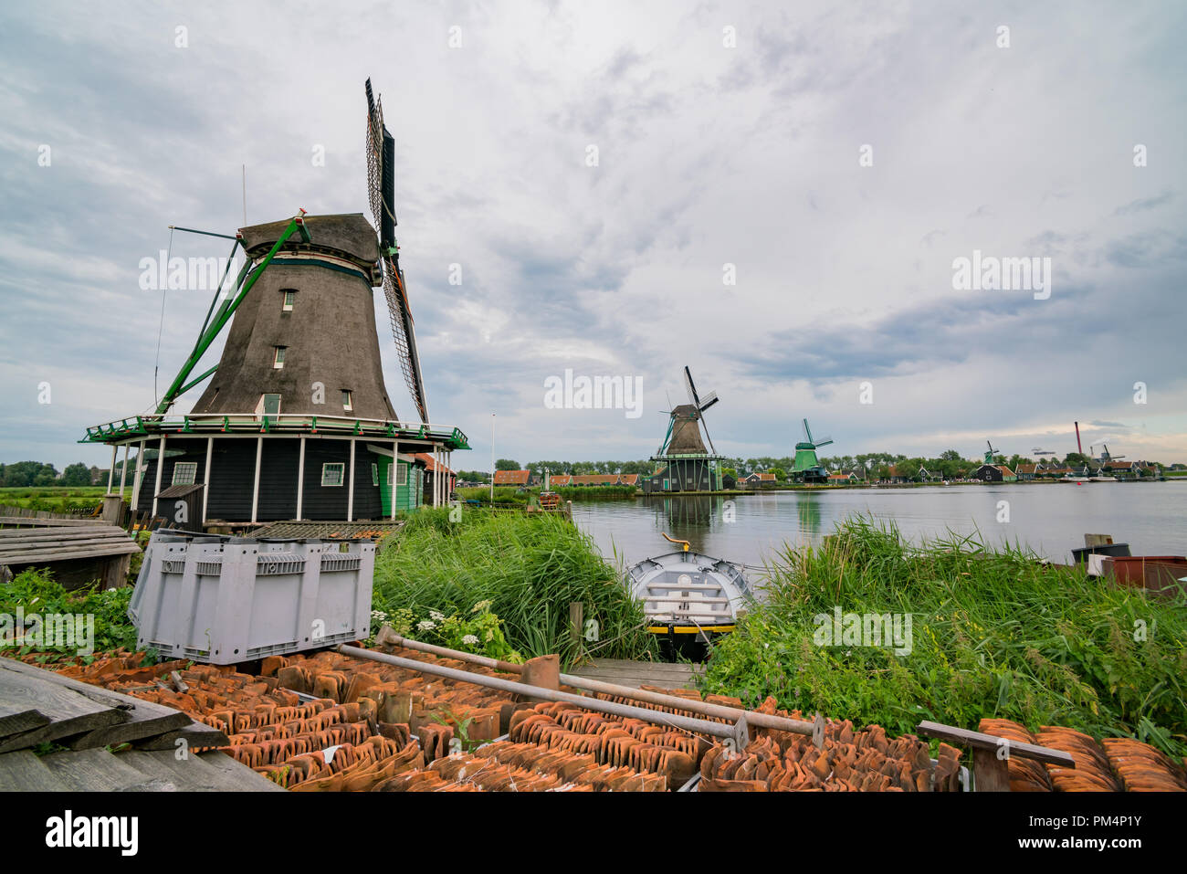 De Gekroonde Poelenburg, De Kat, Windmühle De Zoeker Windmühle und Blick auf den Fluss in Zaandijk, Niederlande Stockfoto