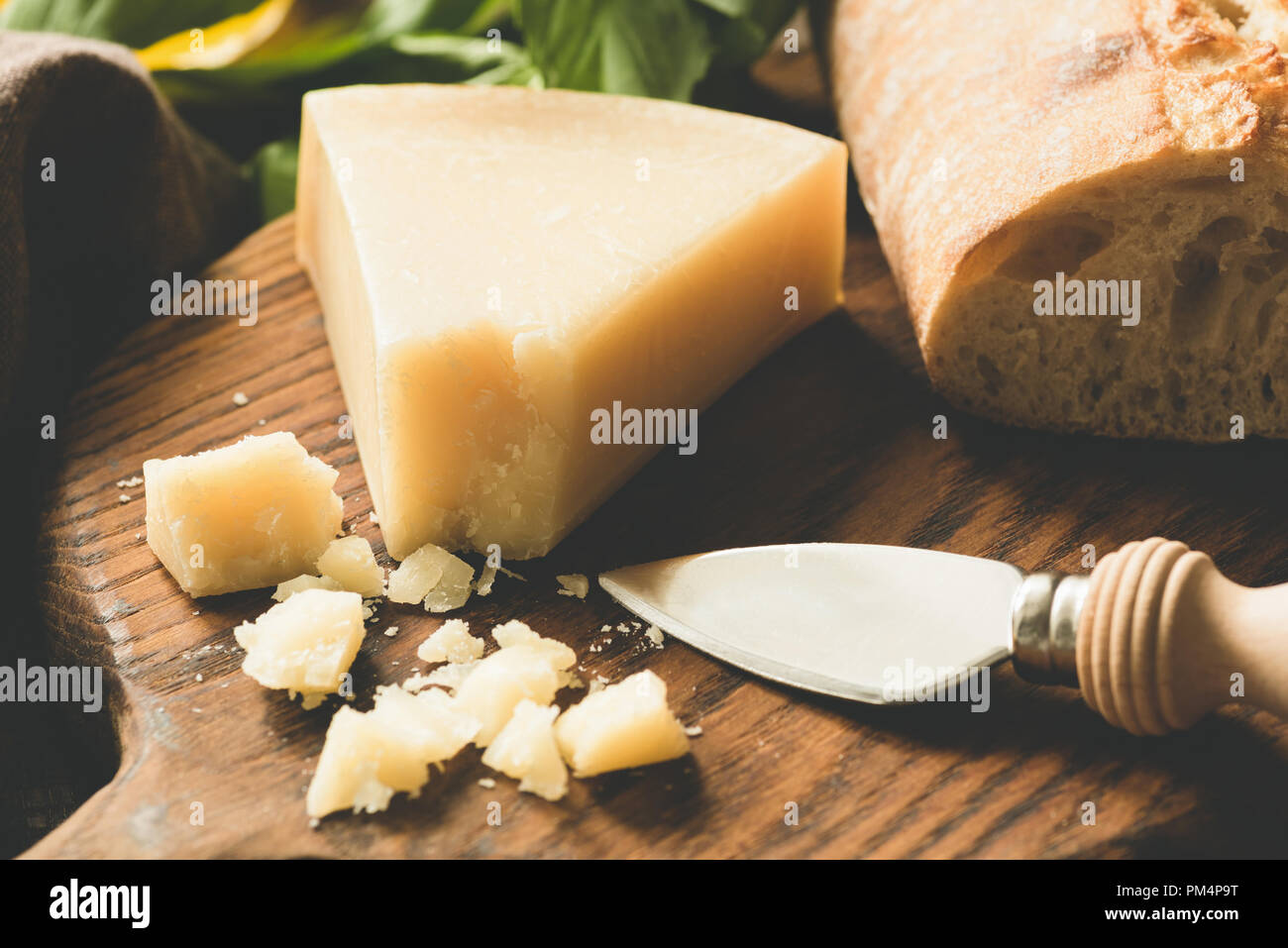 Parmesan- und Käsemesser auf Holzbrett. Getonten Bild, selektiver Fokus Stockfoto