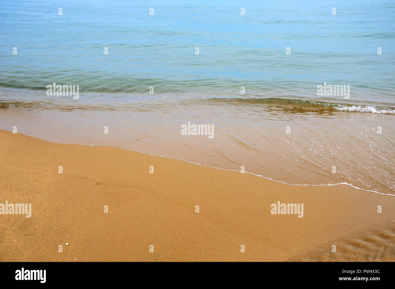 Nasser Sand am Strand. Ein Teil des Meeres ist sichtbar. Stockfoto