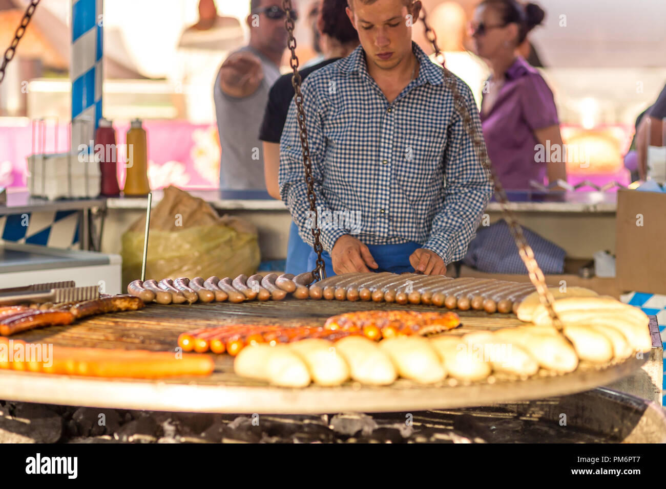 CERVIA (RA), Italien - 16. SEPTEMBER 2018: Mann kochen Würstchen und Brot auf Grill wie die bayerische Küche im europäischen Markt, Straße Ausstellung o Stockfoto