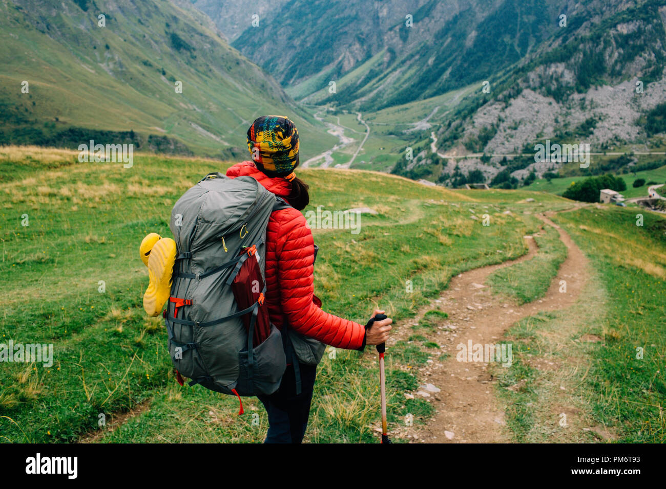 Eine Frau mit einem Rucksack, mit Blick auf das Tal. Wandern rund um den Mont Blanc, Frankreich, Alpen Stockfoto