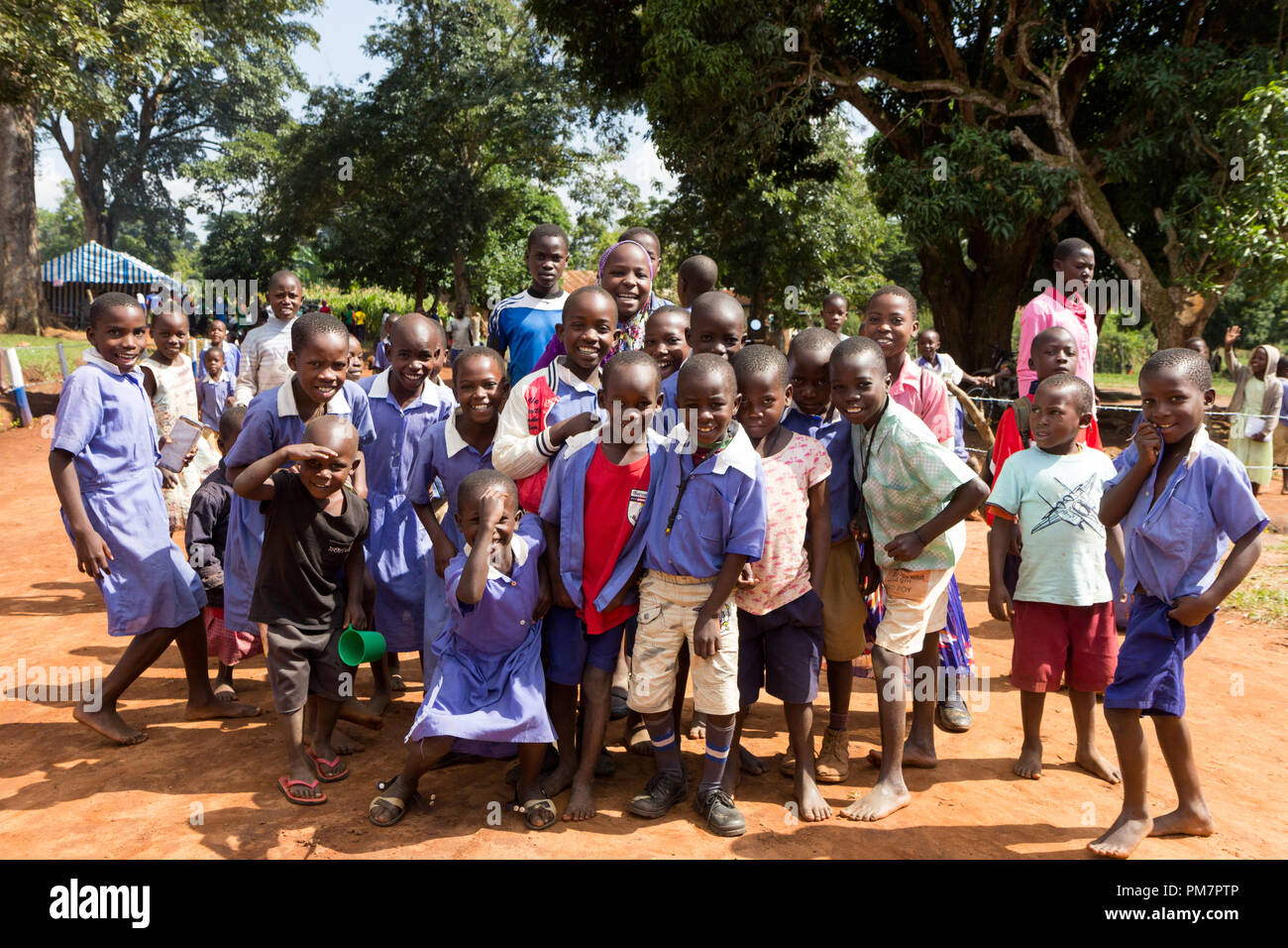 Uganda. 30. Juni 2017. Eine Gruppe von glücklich Vor allem grundschulkinder lächeln, lachen und winken. Stockfoto