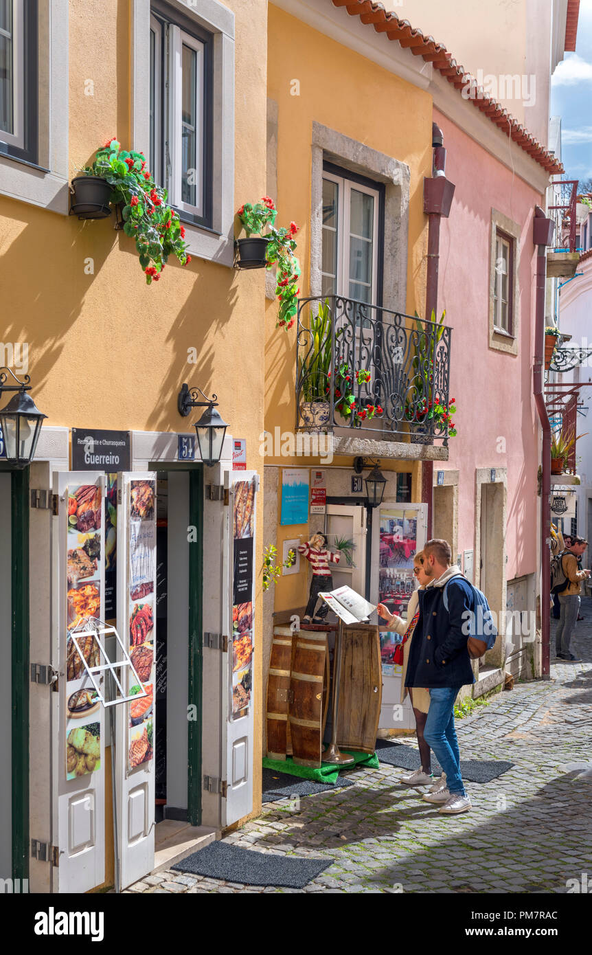 Auf der Suche in einem Menü, die außerhalb einer Gaststätte auf der Rua de Santa Cruz do Castelo in der Nähe von São Jorge, Alfama, Lissabon, Portugal Stockfoto