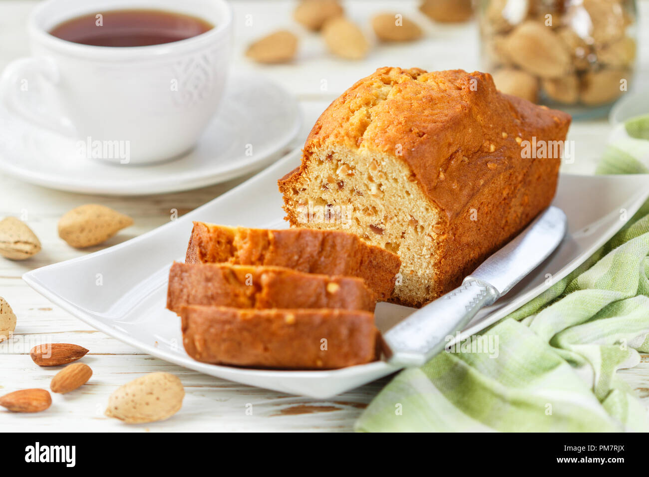 In Scheiben geschnitten pound Kuchen mit Mandeln auf dem Schneidebrett. Hausgemachte Kuchen mit Nüssen und Honig. Delikatesse Snack für Tee. Selektiver Fokus Stockfoto