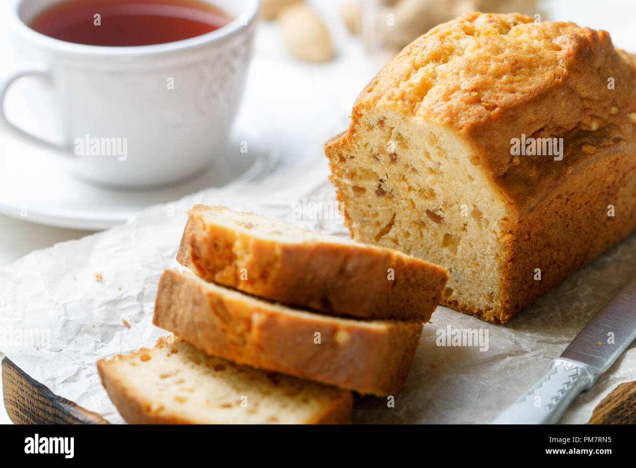 In Scheiben geschnitten pound Kuchen mit Mandeln auf dem Schneidebrett. Hausgemachte Kuchen mit Nüssen und Honig. Delikatesse Snack für Tee. Selektiver Fokus Stockfoto