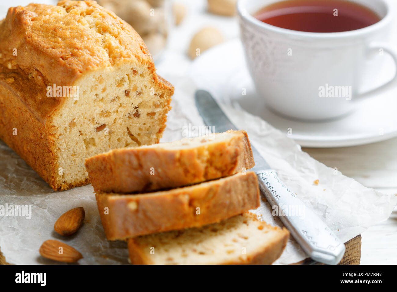 In Scheiben geschnitten pound Kuchen mit Mandeln auf dem Schneidebrett. Hausgemachte Kuchen mit Nüssen und Honig. Delikatesse Snack für Tee. Selektiver Fokus Stockfoto