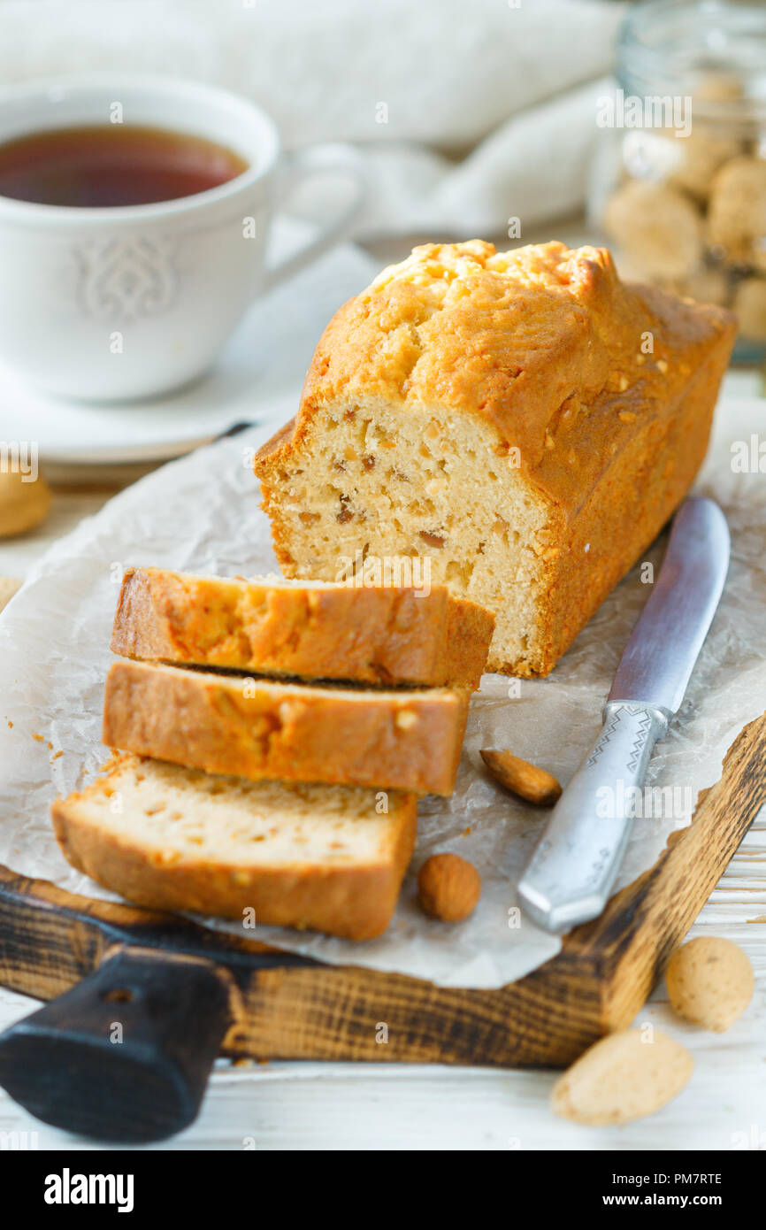 In Scheiben geschnitten pound Kuchen mit Mandeln auf dem Schneidebrett. Hausgemachte Kuchen mit Nüssen und Honig. Delikatesse Snack für Tee. Selektiver Fokus Stockfoto