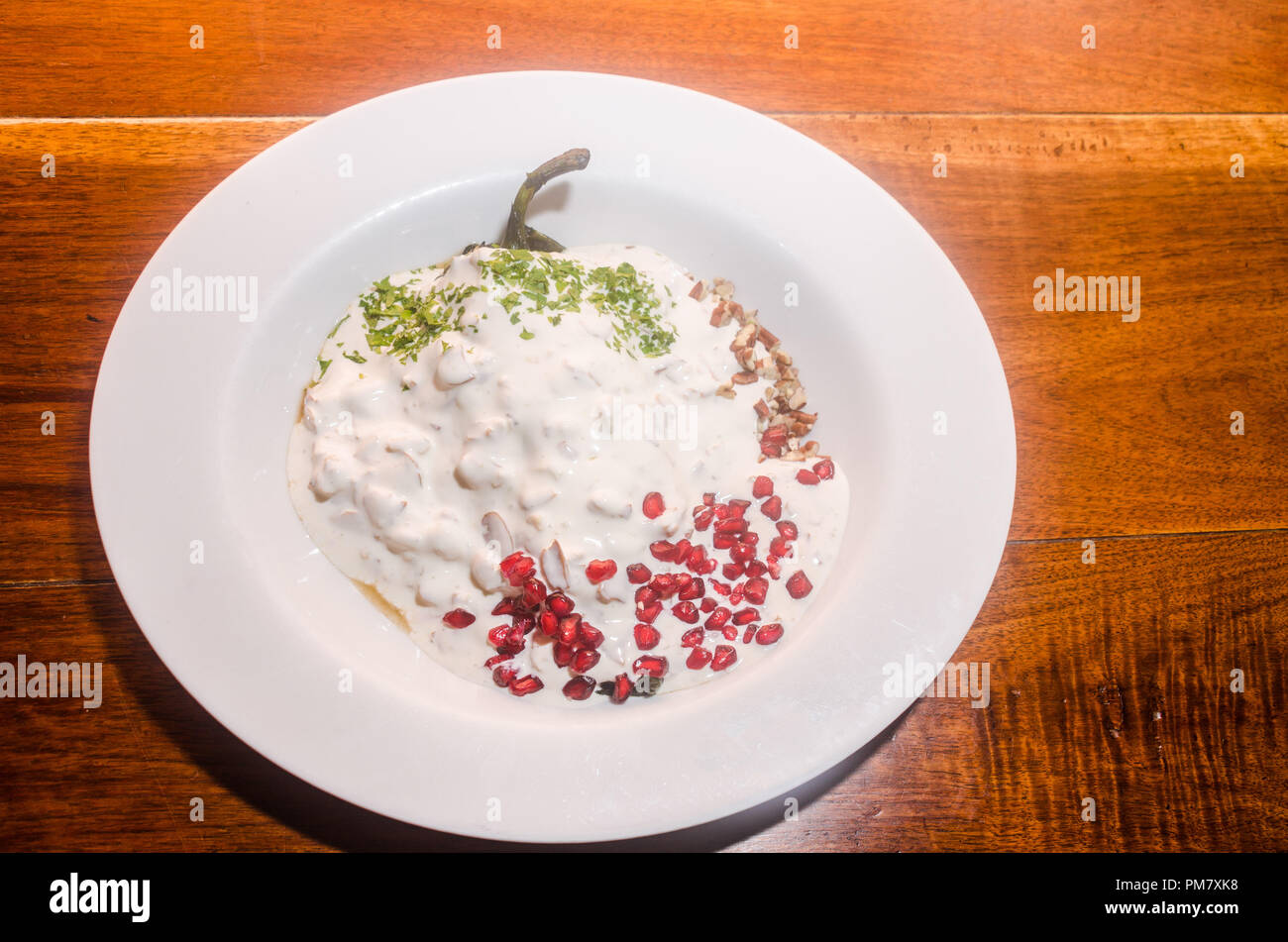 Saisonale mexikanische Gourmet Teller mit Chili mit Fleisch gefüllt und gekleidet mit einer Sauce von Muttern und Granatapfel Stockfoto