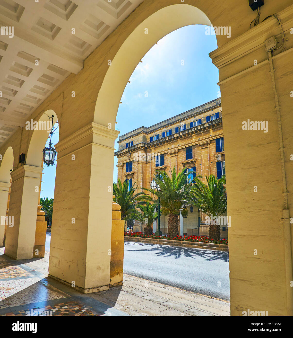 Der Weg in den schattigen Arkaden, Streckung entlang St. Anne Avenue - die zentrale Lage von Floriana, Malta. Stockfoto