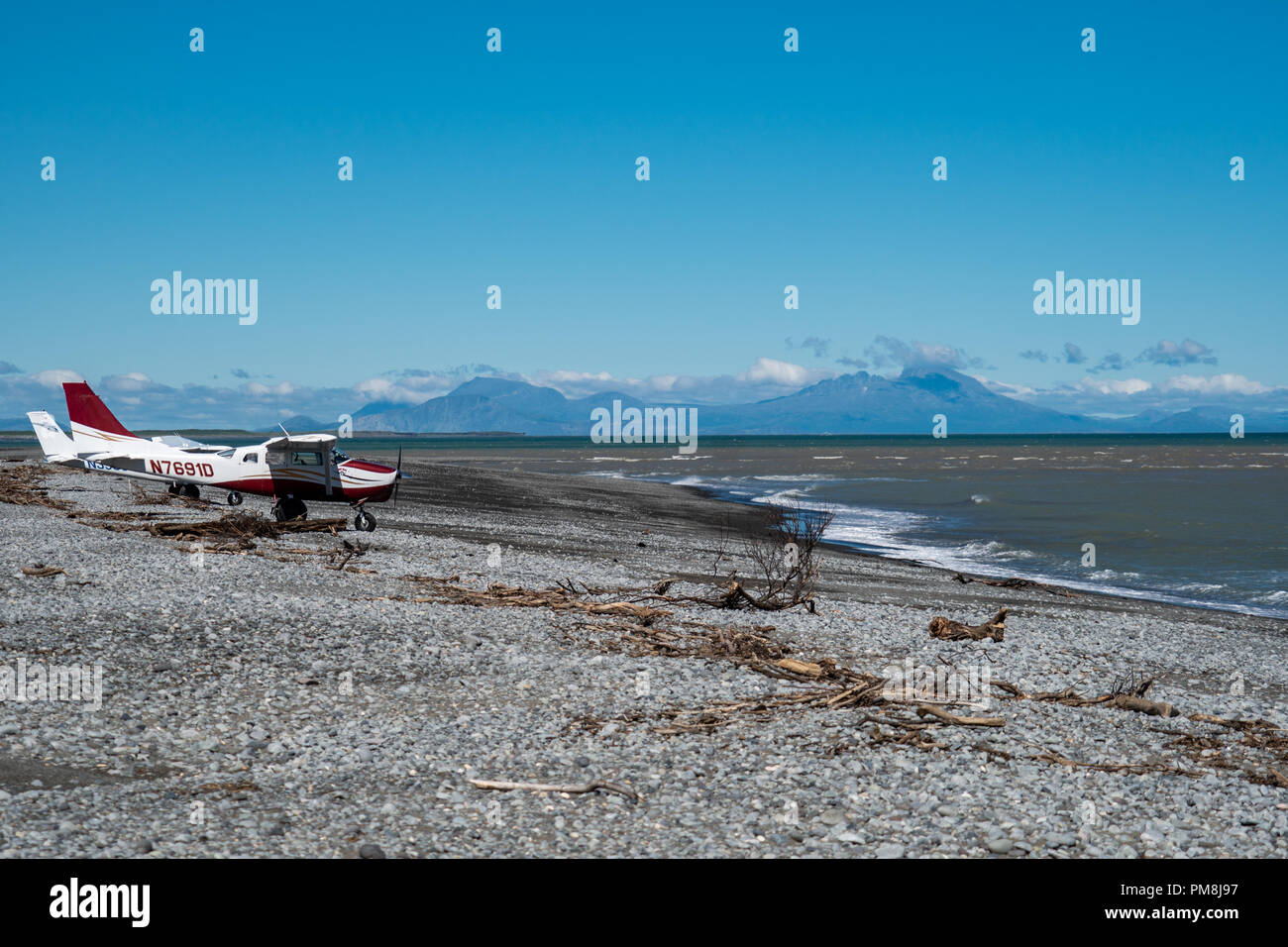 Zwei Cessna bush Flugzeuge auf einem Strand in Alaskas Katmai National Park gelandet. Berge und Vulkane im Hintergrund Stockfoto