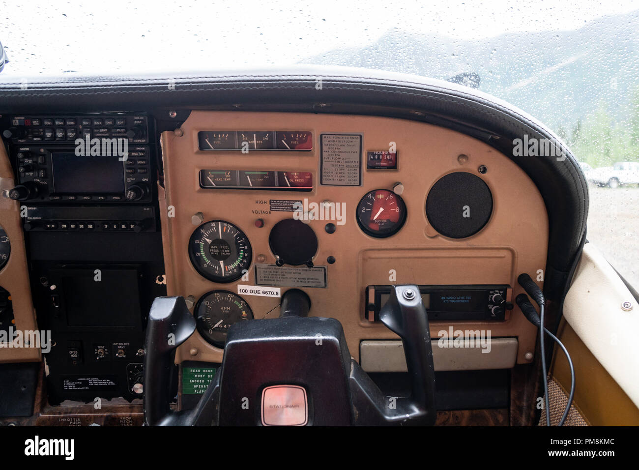 Copilot Steuerelemente innerhalb einer Alaska Bush plane Cessna. Der Instrumententafel, der Windschutzscheibe von Flugzeug mit Regen Stockfoto