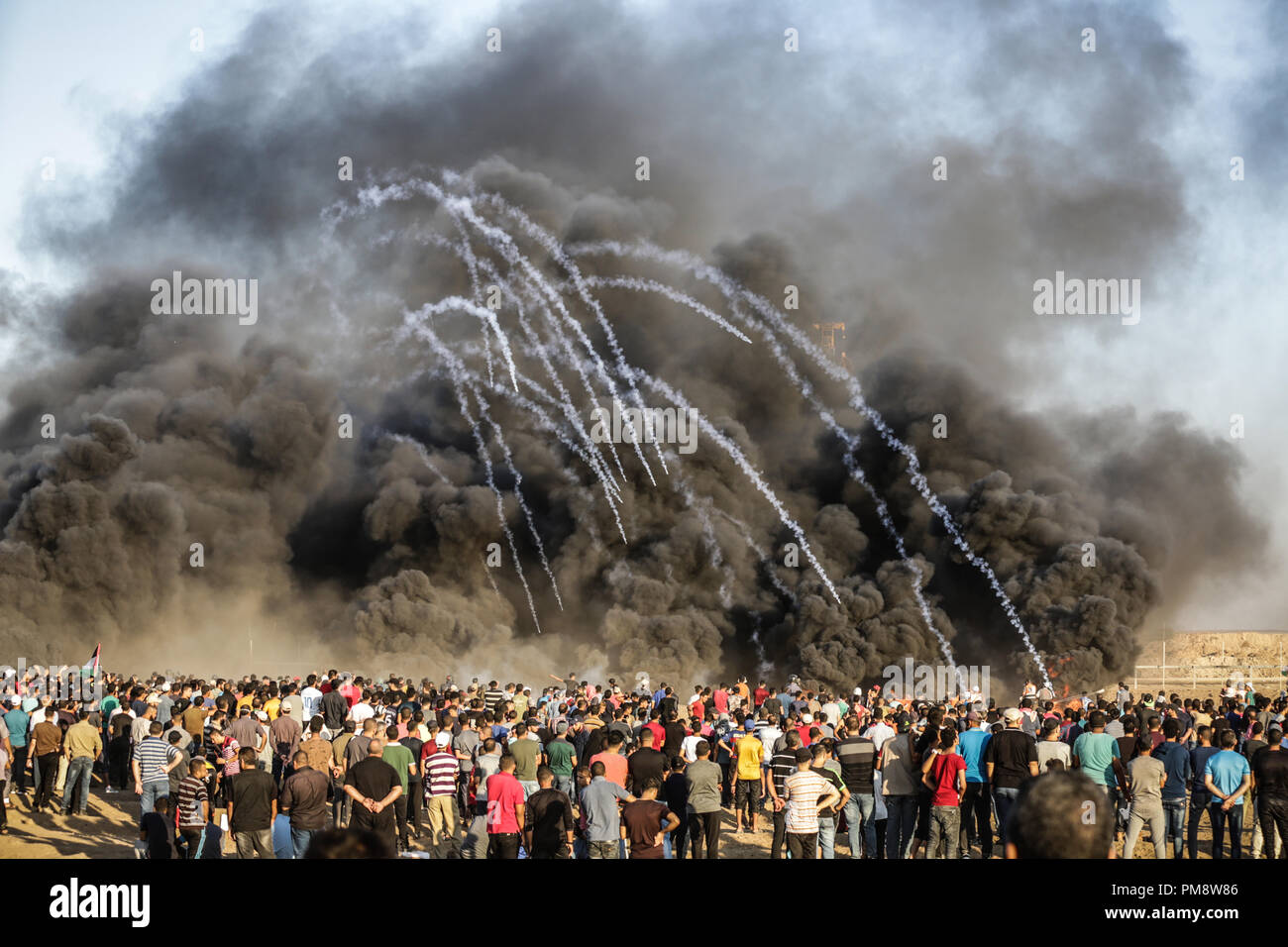 Tränengas und Rauch durch die israelischen Streitkräfte gesehen haben, in eine riesige Menge während der zusammenstöße gefeuert. Auseinandersetzungen zwischen palästinensischen Demonstranten und israelischen Kräfte während eines Protestes entlang der israelischen Zaun östlich von Gaza-stadt. Stockfoto