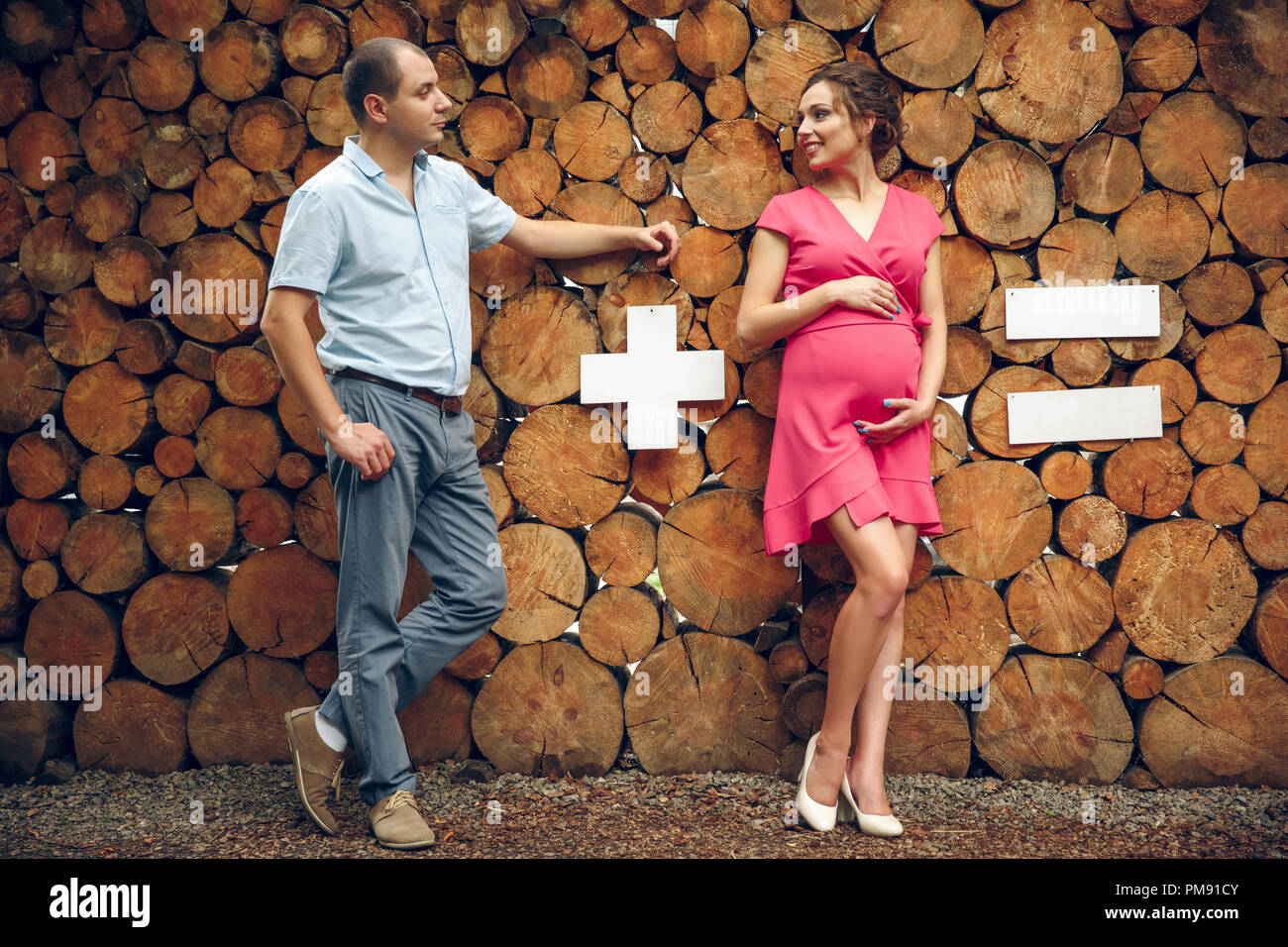 Verliebtes Paar schwanger knuddeln, Warten auf Baby auf Holz- Hintergrund. Mathematische Beispiel Stockfoto