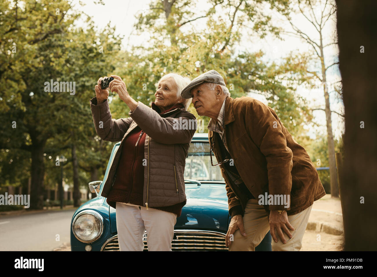 Senior Paar auf Straße Reise Fotos von Natur Landschaft mit Digitalkamera. Alte Frau Fotografieren mit ihrer Kamera mit Mann von Stockfoto