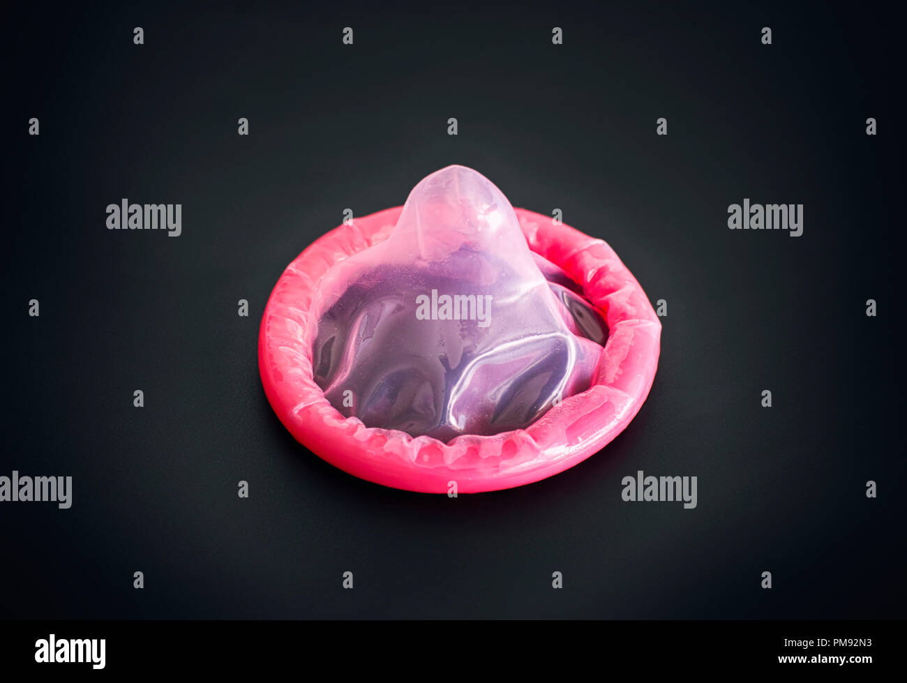 Rosa Kondom auf schwarzen Hintergrund. Close-up Stockfotografie - Alamy