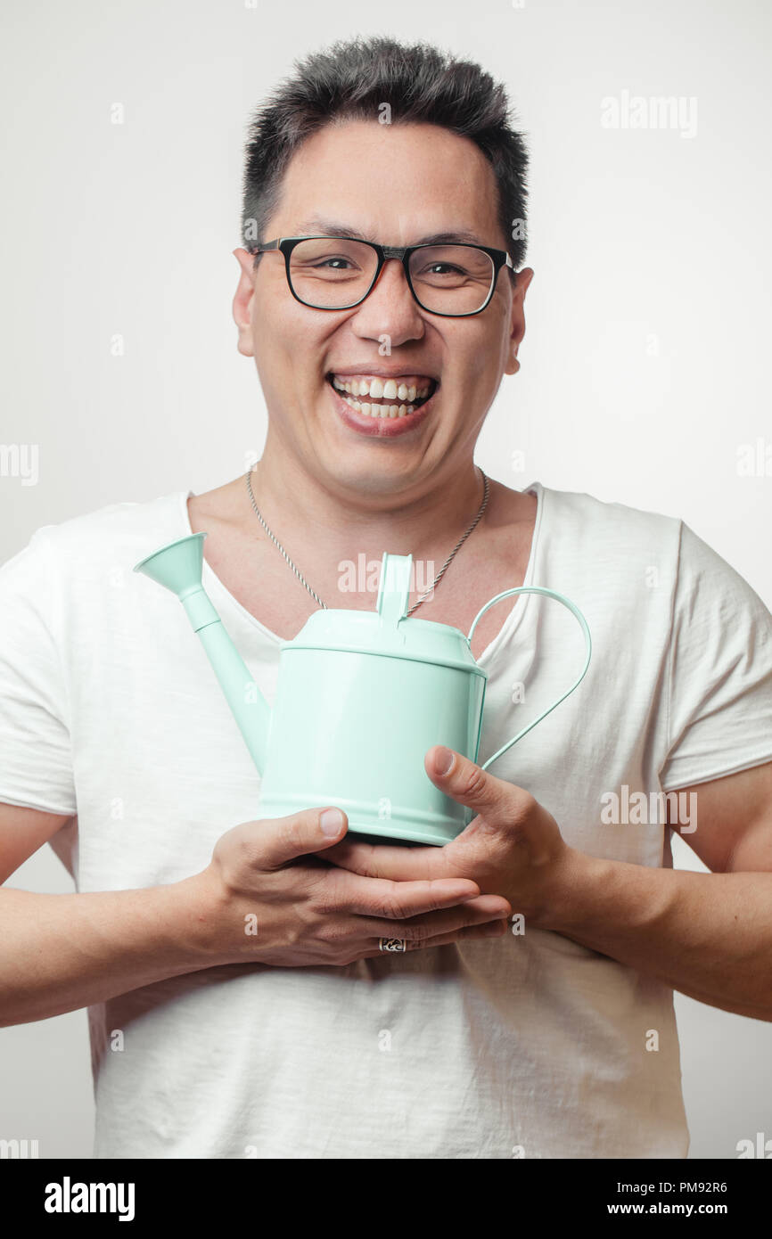 Gerne lustig asiatischer Mann in seinem 30s in Weiß üblichen t-shirt mit verschiedenen positiven Emotionen Stockfoto