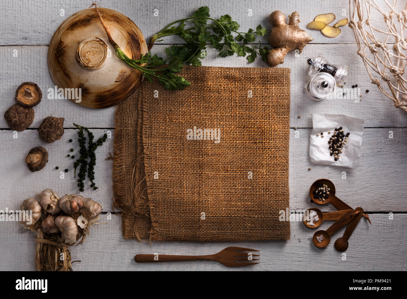 Thai Food Zutaten zum Kochen mit Ingwer, Koriander, Pfeffer, Salz, Knoblauch, lackiert, Gabel, Topf Deckel und Sack auf weißem Holzbrett Hintergrund. Stockfoto