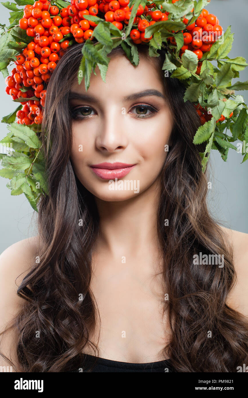 Closeup Portrait von junge Frau mit braunen Haaren, natürliches Make up und roten Beeren und Blätter Kranz Stockfoto