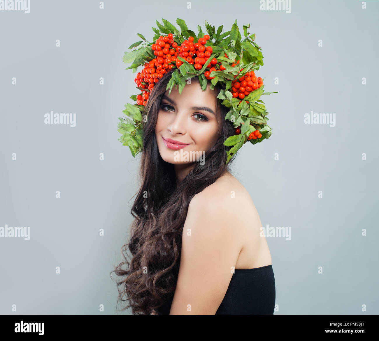 Schöne junge Frau in roten Beeren und grüne Blätter Kranz, Porträt Stockfoto