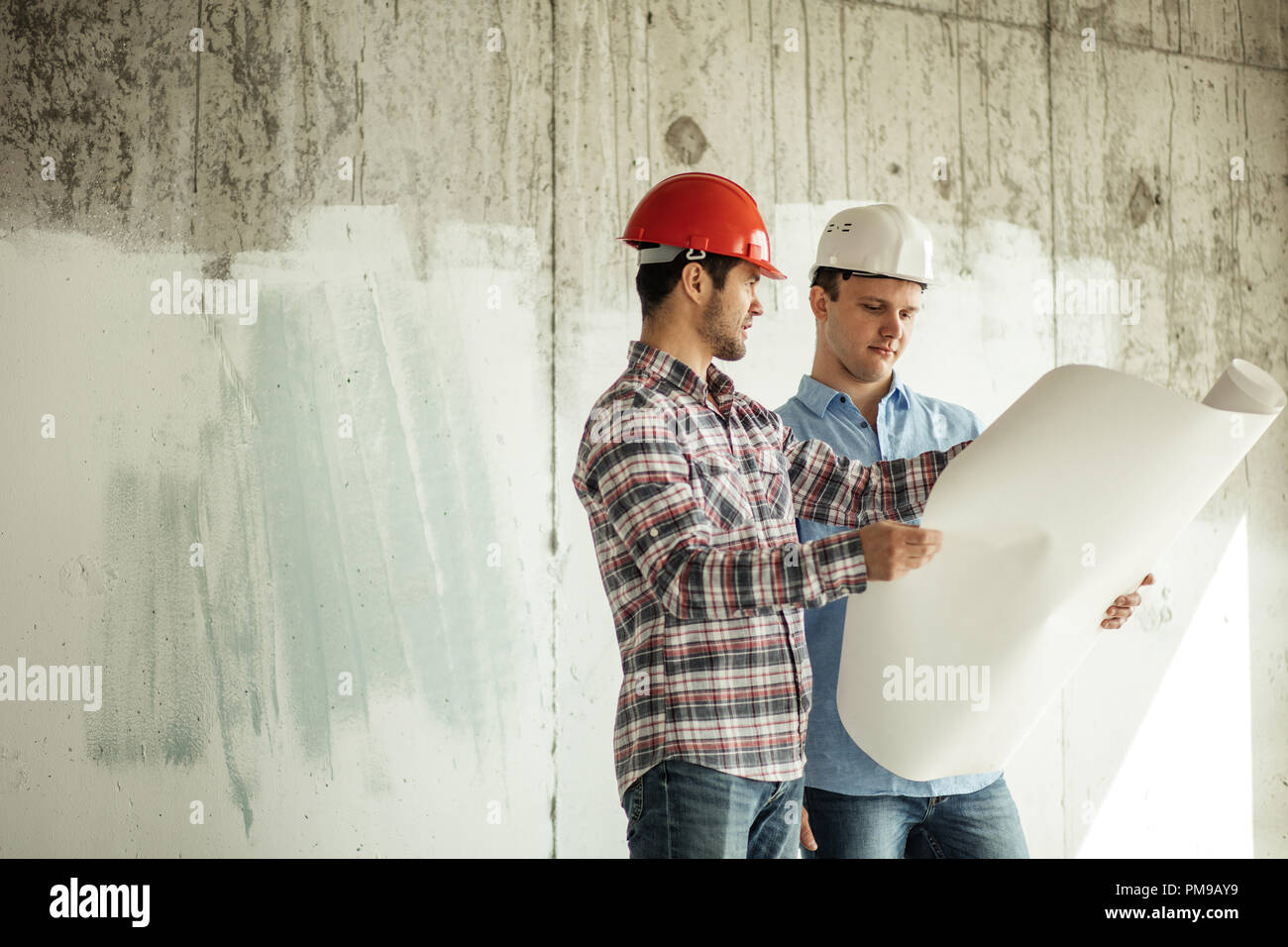 Zwei kreative Baumeister diskutieren Lotation eines Neubaus. Stockfoto