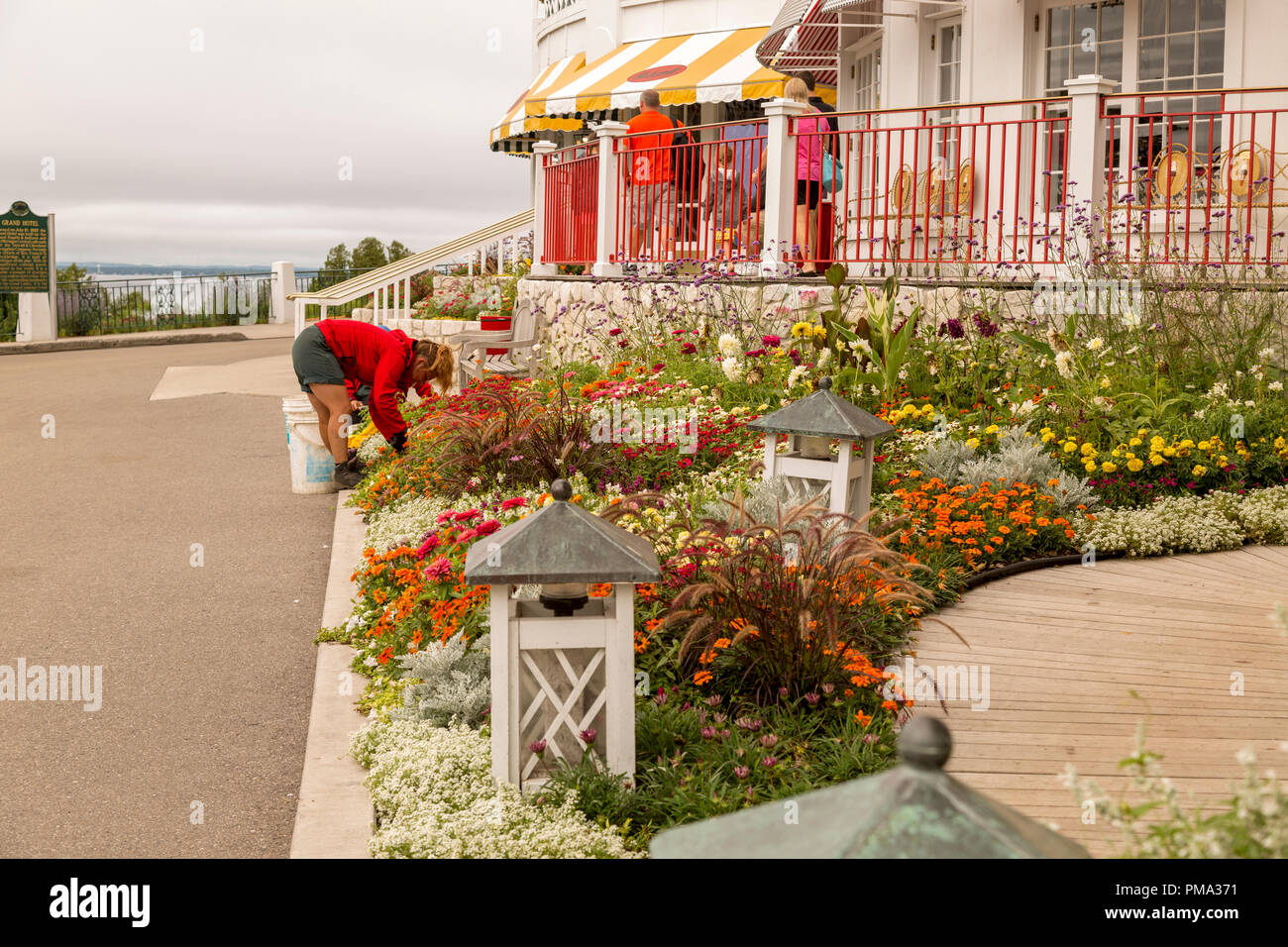 Weibliche Gärtner beugte sich tendenziell die Gärten vor dem Grand Hotel auf Mackinac Island, Michigan. Stockfoto