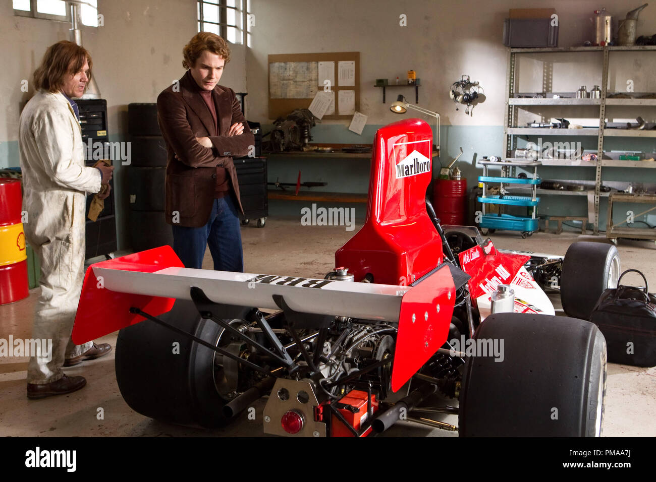 (L, R) ein Brm Mechaniker (Jamie Sives) durch disziplinierte Österreichische Perfektionist Niki Lauda (Daniel Brühl) in 'Rush' geschult Stockfoto