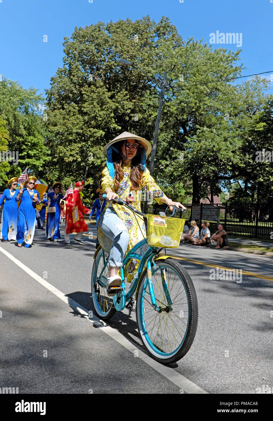 Eine American-Vietnamese Frau reitet ihr Fahrrad in die Parade der Fahnen, die offizielle Eröffnung der 73. jährlichen Eine Welt Tag in Cleveland, Ohio, USA. Stockfoto Eine American-Vietnamese Frau reitet ihr Fahrrad in die Parade der Fahnen, die offizielle Eröffnung der 73. jährlichen Eine Welt Tag in Cleveland, Ohio, USA. Stockfoto
