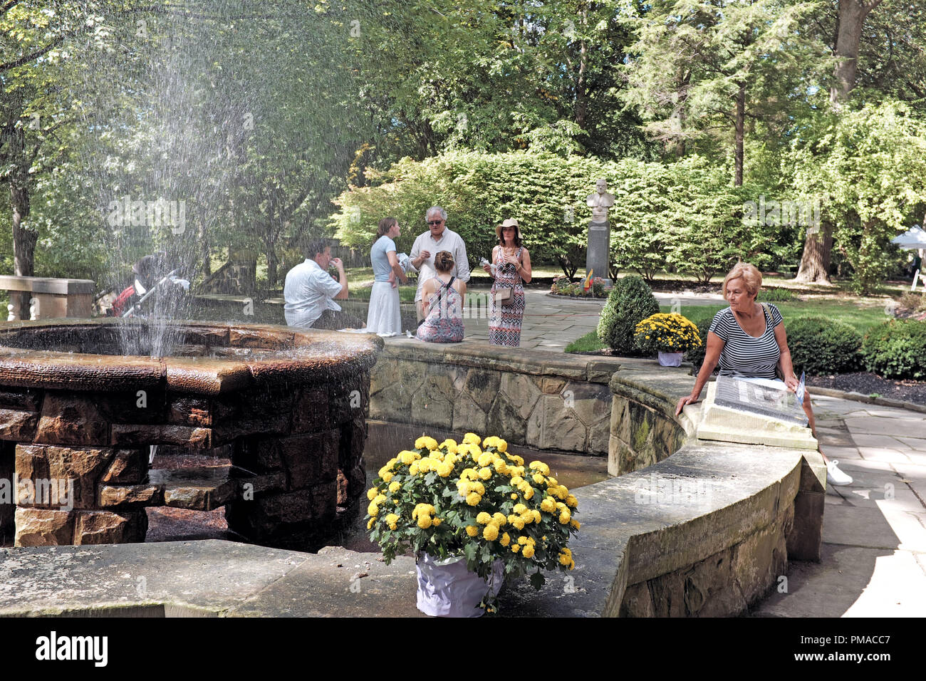 Menschen um eine Wasserfontäne in der Litauen kulturellen Garten in Cleveland Rockefeller Park während der 73. jährlichen One World Tag Feier entspannen Stockfoto