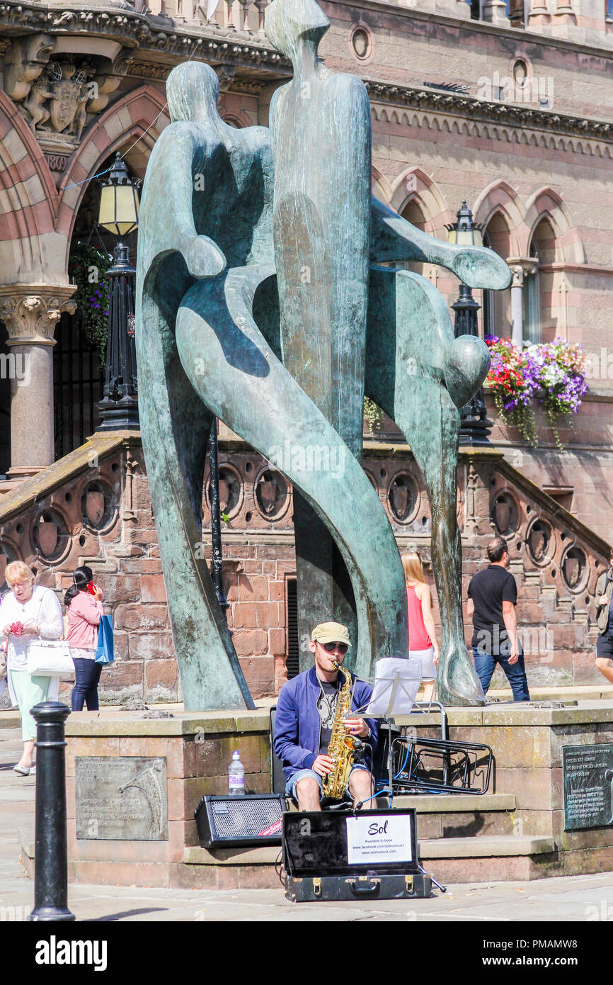 Chester, England - 16. August 2016: ein strassenmusikant spielt das Saxophon von Statue vor dem Rathaus. Die Statue ist von Stephen Broadbent. Stockfoto