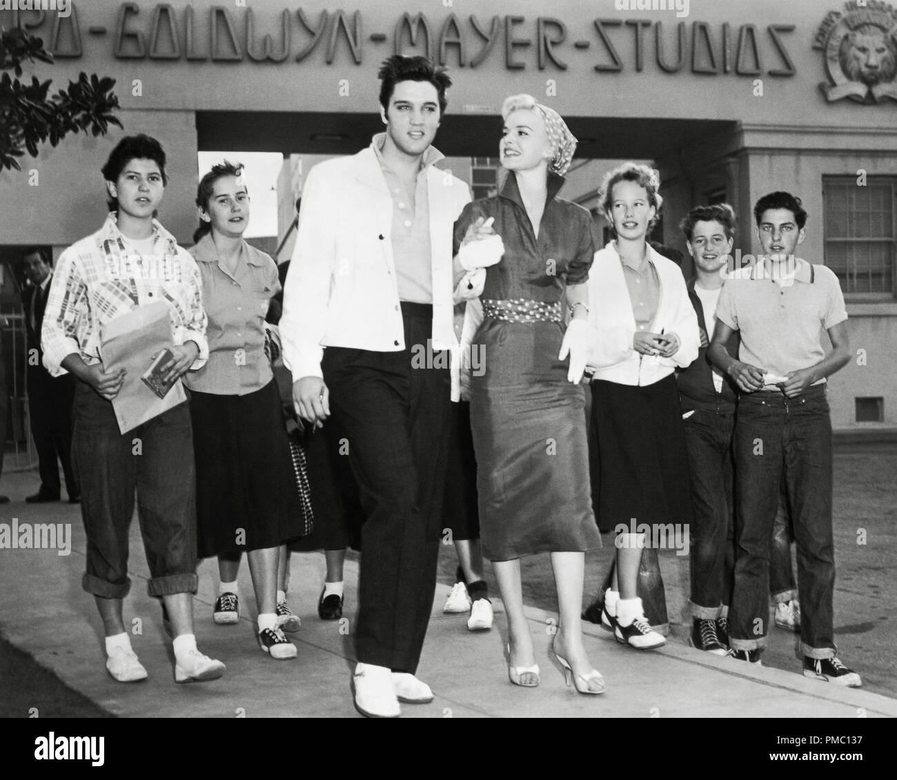 Werbefoto von Elvis Presley und Barbara lang mit Fans, die das MGM-Grundstück in Culver City besuchen, bevor sie mit der Arbeit an „Jailhouse Rock“ beginnen. Lang wurde ursprünglich als Hauptrolle gegenüber Presley besetzt. (1957) MGM-Dateireferenz # 33595 101THA Stockfoto