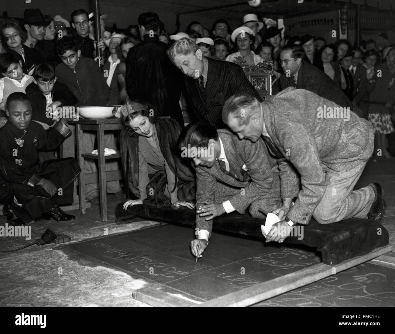 Tyrone Power, war gerade dreiundzwanzig, als er mit seiner Drucke in Zement am Grauman's Chinese Theater, geehrt. Er am 31. Mai 1937 ausgezeichnet wurde, in einer Zeremonie hielten gemeinsam für ihn und Loretta Young (links), Sid Grauman auch dargestellt hinter ihnen. Datei Referenz # 33595 501 THA Stockfoto