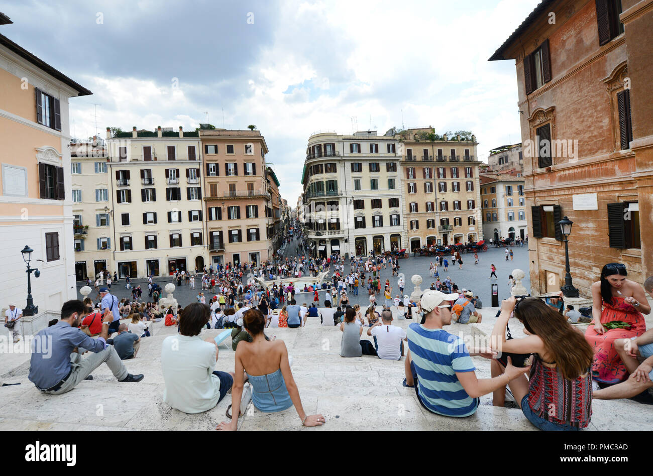 Touristen sitzen auf der Spanischen Treppe und genießen den Blick auf die Piazza di Spagna. Stockfoto