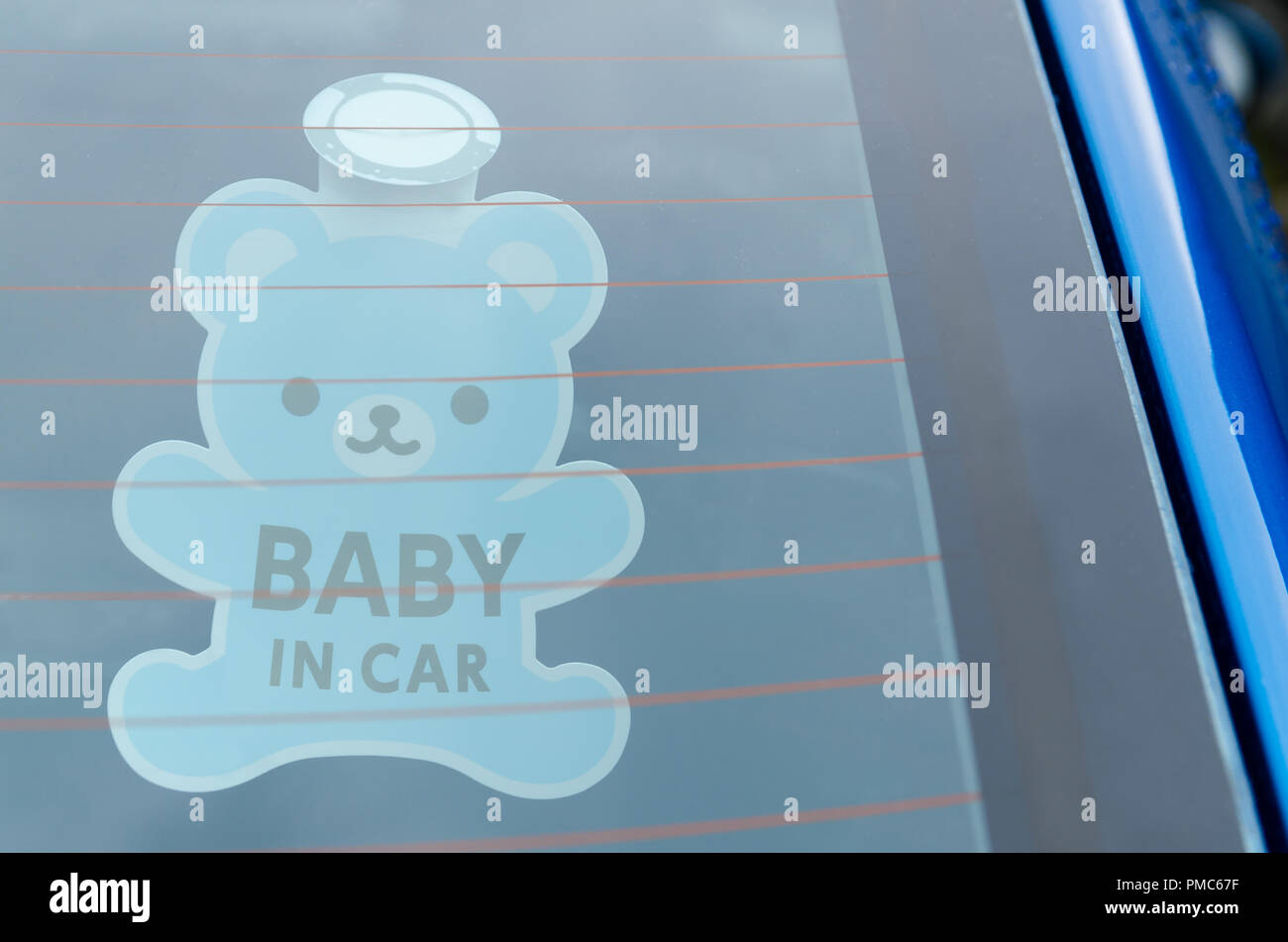 Nahaufnahme der Baby im Auto board Zeichen auf das Auto zurück Glas. Stockfoto