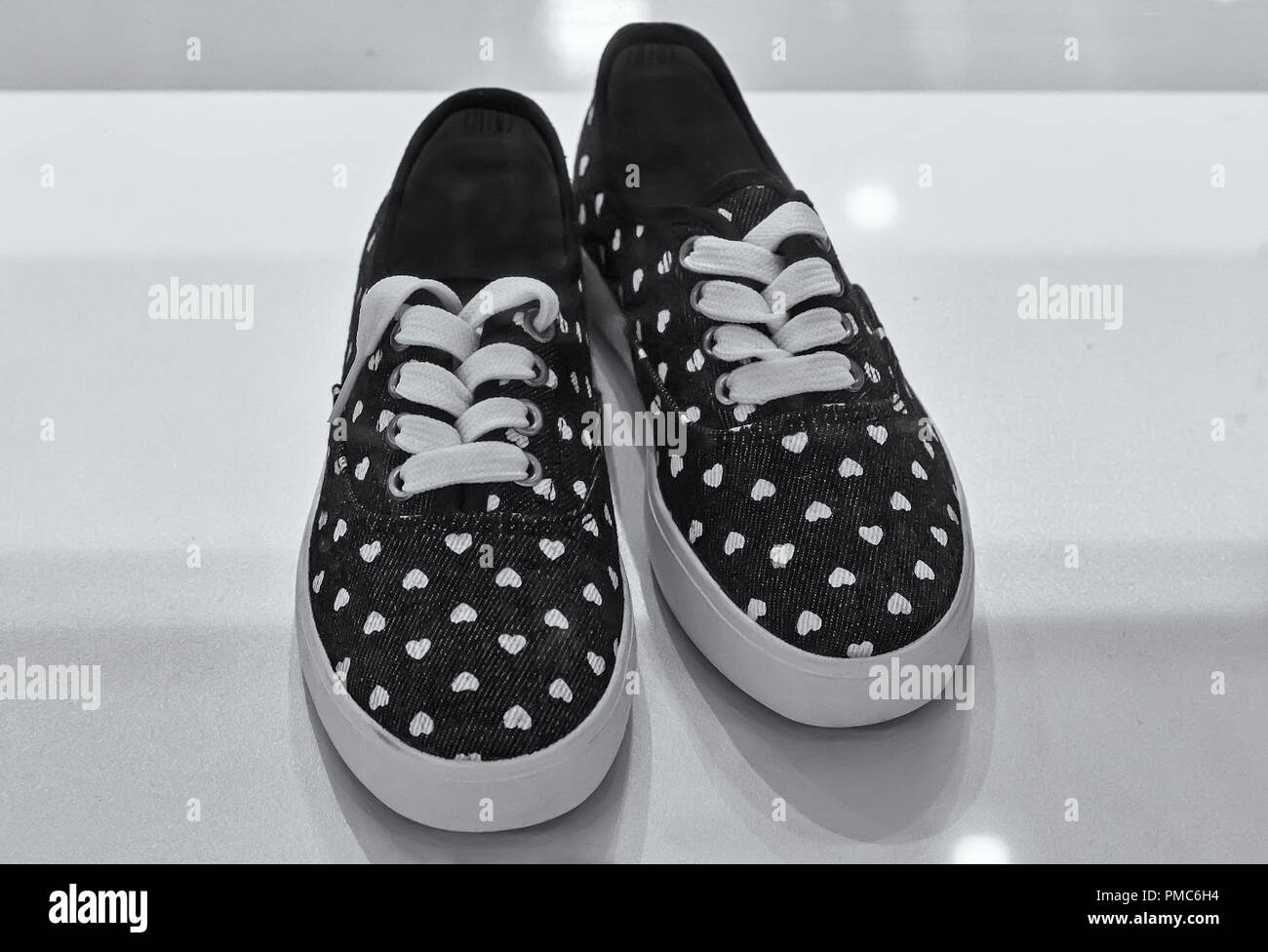 Im Schaufenster ist für sportliche Schuhe Verkauf komfortable Frauen angeboten. Schwarz-/Weiß-Bild. Stockfoto