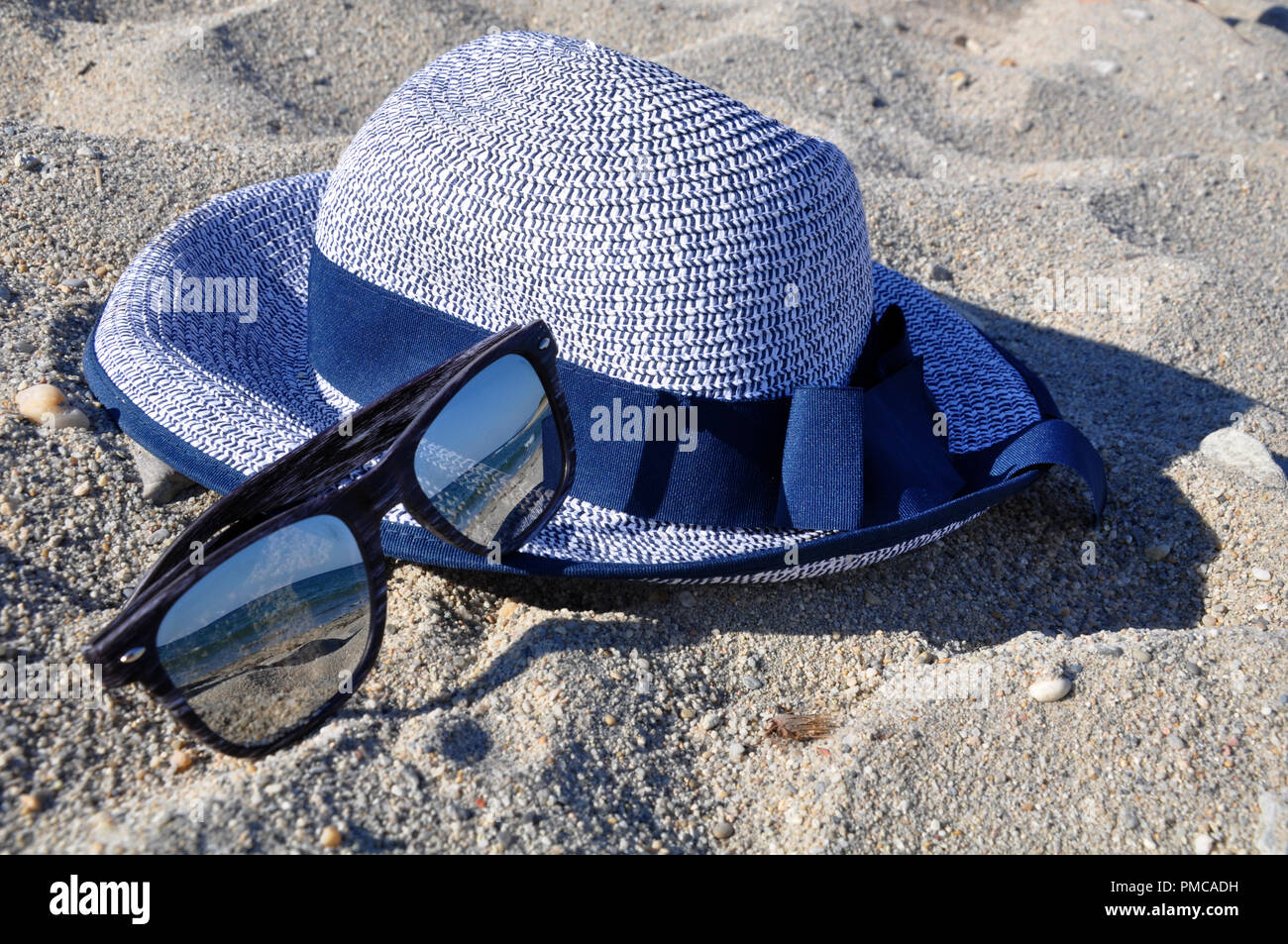 Sonnenbrille und Hut am Strand Stockfoto